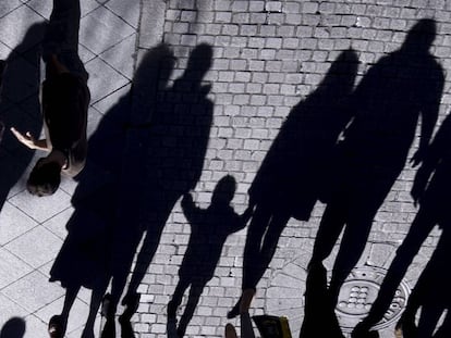 La sombra de un menor y varios adultos en una calle de Sevilla. 