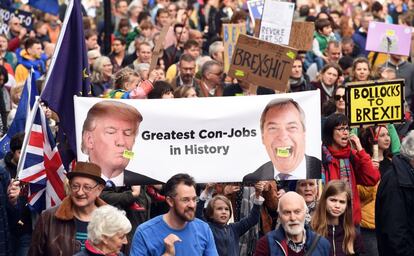 Pancarta con la imagen del presidente de Estados Unidos, Donald Trump, y el político británico Nigel Farage, bajo el eslogan "Los más grandes estafadores de la historia", durante la marcha.
