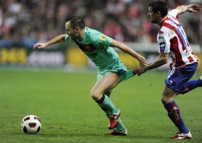 Nacho Novo grabs Iniesta's trousers during the Sporting-Real Madrid match.