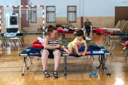Nerea limpia los pies a su hija Naiade, en el pabellón de La Bañeza donde los vecinos afectados por los incendios han sido realojados, el miércoles.