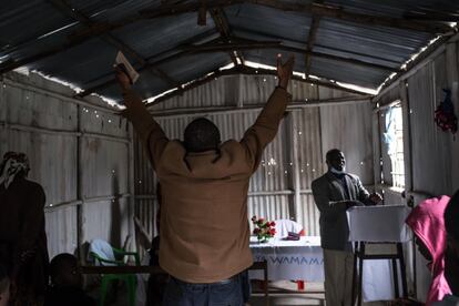 Varios vecinos cantan, rezan y bailan en una pequeña iglesia de chapa en el suburbio de Kawangware, en la capital de Nairobi. Desde el inicio de la pandemia de coronavirus, la policía ha hecho uso de la fuerza para implementar las restricciones anticovid, como el uso de la mascarilla y el toque de queda nocturno.
