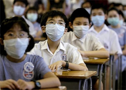 Estudiantes de primaria asisten esta mañana a clases en una escuela de Hong Kong.