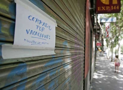 El cartel de cerrado por vacaciones, sobre la persiana bajada de un negocio.