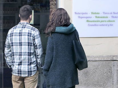 Una pareja, frente a un centro de terapias alternativas en Valencia.