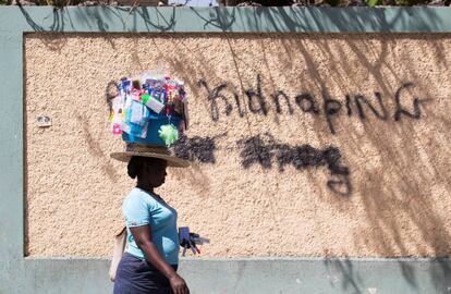 Una mujer pasa junto a un grafiti en el que se lee “Abajo los secuestros” el 16 de febrero en Puerto Príncipe (Haití). Son prácticas largamente denunciadas, pero no resueltas: desde la explotación laboral hasta la prostitución y la servidumbre; cada año, más de 50.000 menores haitianos cruzan al país vecino, República Dominicana (150 cada día). Muchos de ellos son traficados y vendidos con oscuros propósitos.