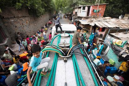 Los residentes usan mangueras el martes para recolectar agua potable de un camión cisterna durante un caluroso día de verano en Nueva Delhi, la India.