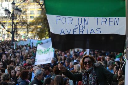 Manifestante porta una bandera de Extremadura con el lema "Por un tren sin averías".