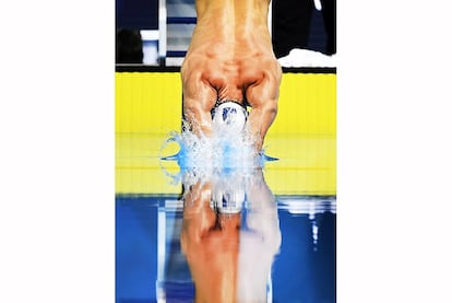 Michael Phelps se sumerge en el inicio de la final masculina de los 100 metros mariposa en las pruebas olímpicas de natación EE.UU. en Omaha, Nebraska . Phelps ganó la carrera.