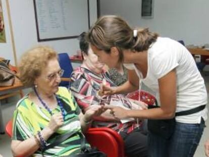 Africa, paciente de una residencia de mayores, hace terapia con la psicóloga Elena Ojeda y la hembra de labrador Tirma dentro del proyecto piloto puesto en marcha en Gran Canaria por la empresa Nahai para ofrecer terapias personalizadas y en sus propias residencia a las personas mayores. EFE/Archivo