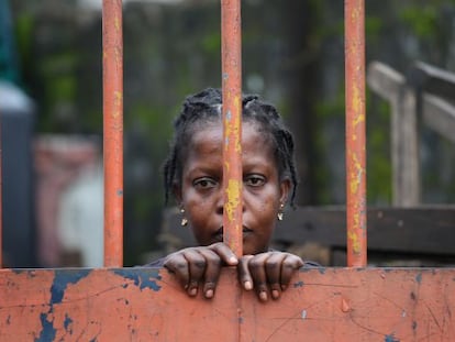 Una residente del West Point, un suburbio de Monrovia (Liberia), detr&aacute;s de una de las vallas que cierra el barrio por la cuarentena ante el &eacute;bola. 