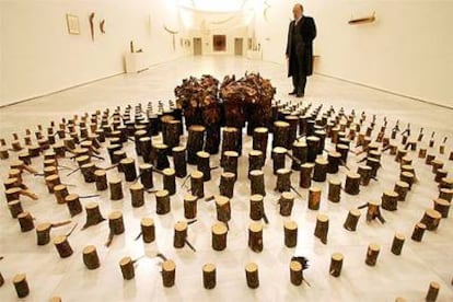 Una vista de la exposición de Adolfo Schlosser en el Reina Sofía, con la instalación de pinos cortados y quemados <i>El cielo sobre la tierra </i><b>(1994</b>).