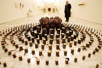 Una vista de la exposición de Adolfo Schlosser en el Reina Sofía, con la instalación de pinos cortados y quemados <i>El cielo sobre la tierra </i><b>(1994</b>).