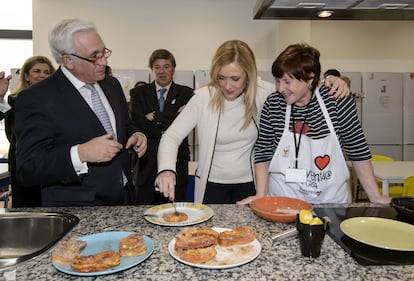 Cristina Cifuentes, en el centro, prueba una de las torrijas elaborada por voluntarias del hogar.