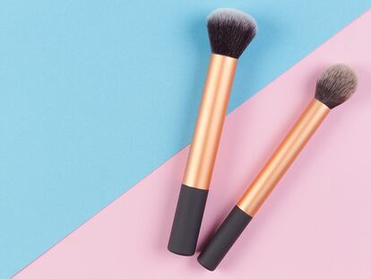 Make up brushes on pink and blue background. Top view.