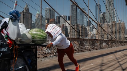 Una vendedora de fruta cruza el puente de Brooklyn Bridge durante una ola de calor, este martes en Nueva York.