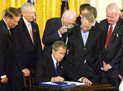 El presidente George W. Bush firma la nueva ley antiterrorista en presencia de varios congresistas.