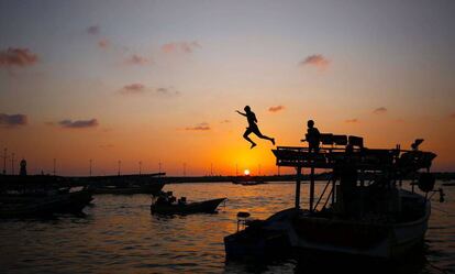 Un niño salta al agua con el atardecer de fondo, en la Franja de Gaza.
