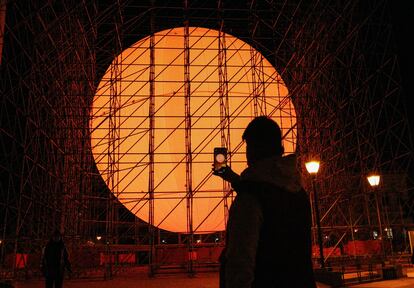 Un joven fotografía la gran instalación de arte urbano del artista Spy en la Plaza de Colón.