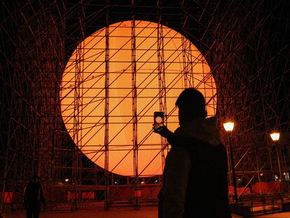 Un joven fotografía la gran instalación de arte urbano del artista Spy en la Plaza de Colón.