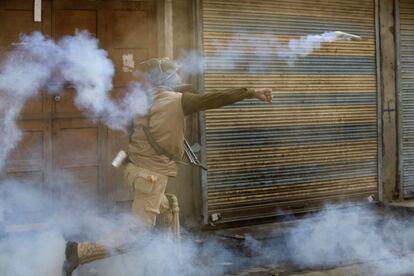 Un policía de lndia lanza gas lacrimógeno para dispersar a los manifestantes musulmanes durante una protesta en Srinagar (Cachemira) controlada por agentes indios.