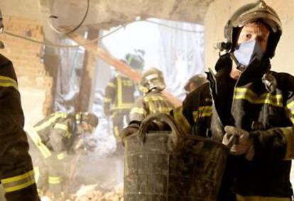 Varios bomberos sacan escombros en el derrumbe de la calle General Martínez Campos. 