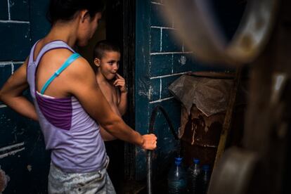 Llenando botellas para ahorrar agua para los próximos días.