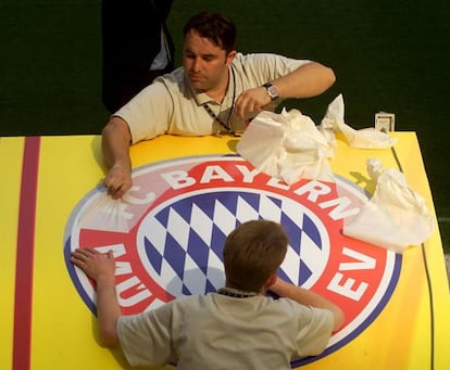 Unos trabajadores colocan un escudo del Bayern de Múnich, en el estadio de San Siro, un día antes de la final de la Copa de Europa contra el Valencia FC en 2001