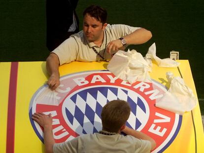 Unos trabajadores colocan un escudo del Bayern de Múnich, en el estadio de San Siro, un día antes de la final de la Copa de Europa contra el Valencia FC en 2001