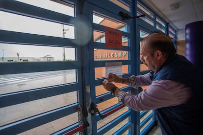 El conserje del IES Miralcamp de Villarreal de Castellón coloca el aviso de suspensión de las clases este jueves.