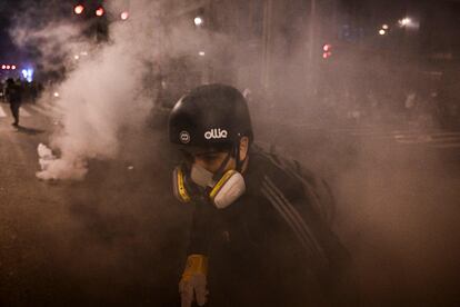 Un partidario del expresidente Pedro Castillo se protege de los gases lacrimógenos lanzados por la policía durante los enfrentamientos en Lima, el domingo.
