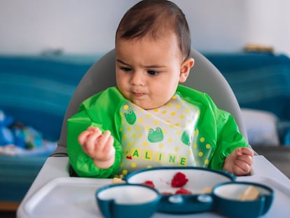 Baby making funny faces while eating breakfast. Blw concept