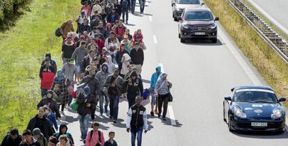 Centenares de refugiados, en su mayor&iacute;a sirios, transitan por una autov&iacute;a en Dinamarca. 