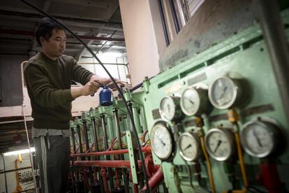 El mecánico Than Htike, de 38 años, engrasa el motor principal del buque pesquero. r’