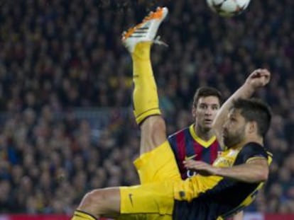 Diego despeja ante la mirada de Messi.