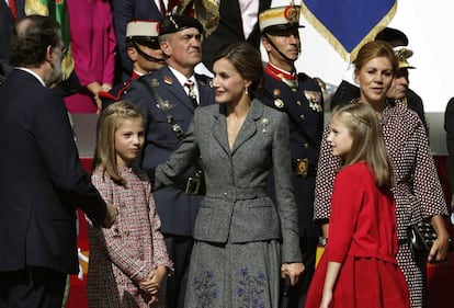 La reina Letizia, vestida de Felipe Varela, junto a la princesa Leonor y la infanta Sofía; y el presidente del Gobierno, Mariano Rajoy, y la ministra de Defensa, María Dolores de Cospedal.