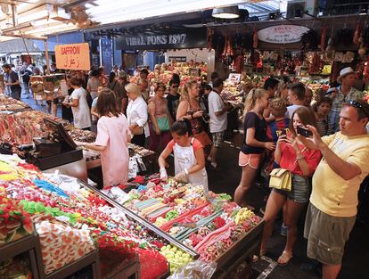 Turistas haciendo fotos a los puestos de la Boqueria.