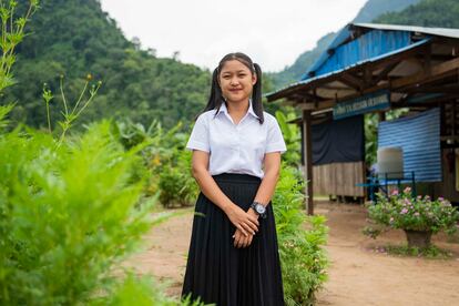 Noi Si, de 17 años y alumna del colegio U Moo Ta, posa para un retrato junto al pabellón principal.