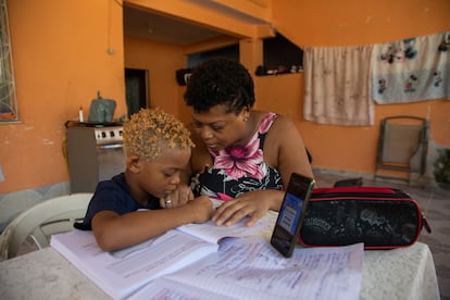 A mãe de Isaac, Marcela da Silva, tenta ajudá-lo a manter uma rotina escolar. 