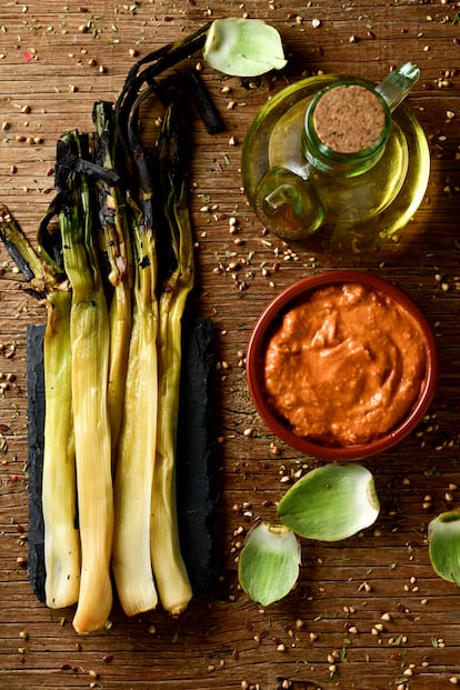 Los 'calçots' asados se acompañan de la salsa romesco.