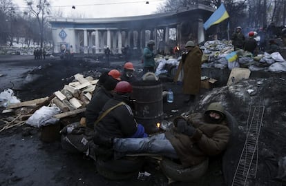 Varios manifestantes tratan de entrar en calor en torno a una hoguera, durante una protesta antigubernamental en Kiev (Ucrania), 28 de enero de 2014. La oposición ucraniana se apuntó una crucial victoria al lograr que se cumplan dos de sus principales demandas: la dimisión del Gobierno en pleno y la derogación de las leyes represoras que limitaban las libertades fundamentales.