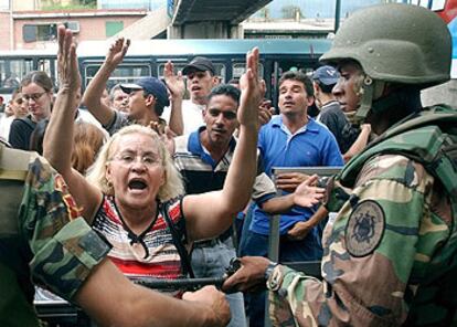 Soldados contienen a la gente que protesta en uno de los puntos de recogida de firmas contra Chávez.