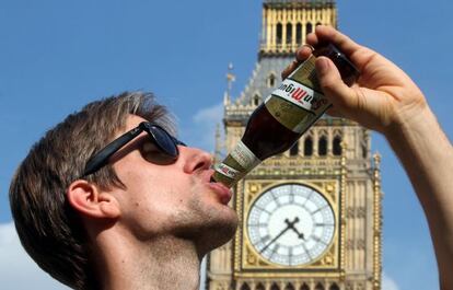 Un hombre bebe una cerveza San Miguel junto al Big Ben, la torre del Parlamento británico.