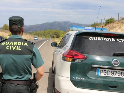 Un agente de la Guardia Civil, junto a un  vehículo patrulla, en una imagen de archivo.