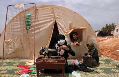 Umm Hussein, una mujer siria desplazada de treinta años, cose mascarillas en un campamento cerca de la ciudad de Maaret Misrin (Siria).