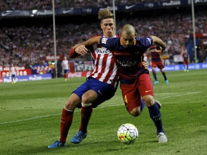 Mascherano disputa amb Torres la pilota.