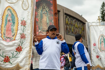 Un hombre carga sobre sus hombros una imagen de la Virgen.