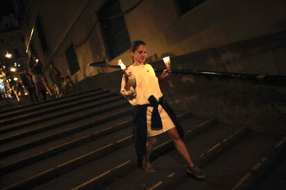 Una joven camina con unas velas por Pamplona la última noche de los Sanfermines en la que los pamplonicos se reúnen para cantar el 'Pobre de mí'.