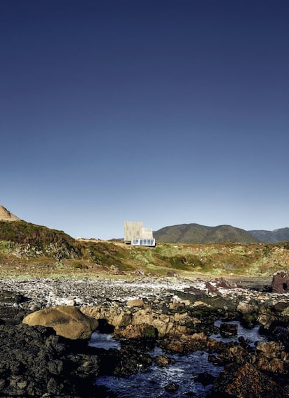 Escultórica, formada por tres volúmenes de hormigón, esta casa busca envejecer como las piedras, confundiéndose con la geografía del lugar. Las zonas comunes de la casa —el salón, la cocina y el dormitorio principal— ocupan la base horizontal y tienen vistas al océano Pacífico.