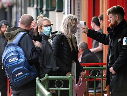 Un guardia de seguridad toma este viernes la temperatura de los clientes de un pub de Liverpool.