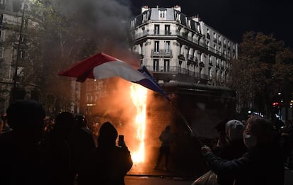 Manifestantes ondean la bandera francesa en París, durante una protesta contra el proyecto de ley de seguridad, que en su artículo 24 penalizaría la publicación de imágenes de policías de turno con la intención de dañar su integridad física o psicológica.